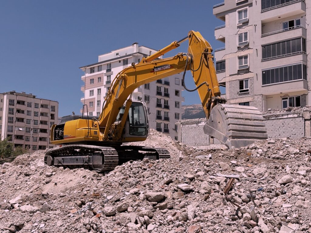 Demolições controladas com técnica e segurança — equipamento pesado em obra de construção civil